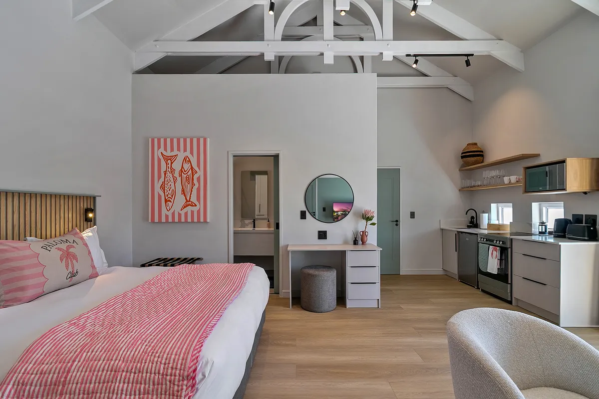 Featherbed suite bedroom with patterned throw and red accent cushion